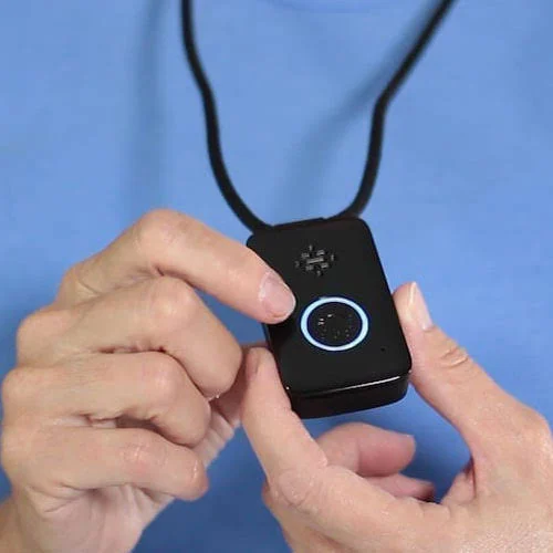A medical alert pendant on a cord, held in two hands